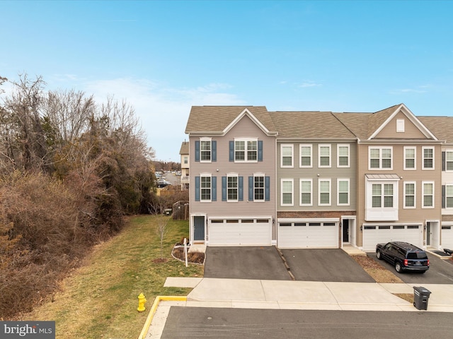 multi unit property with a garage and a front yard