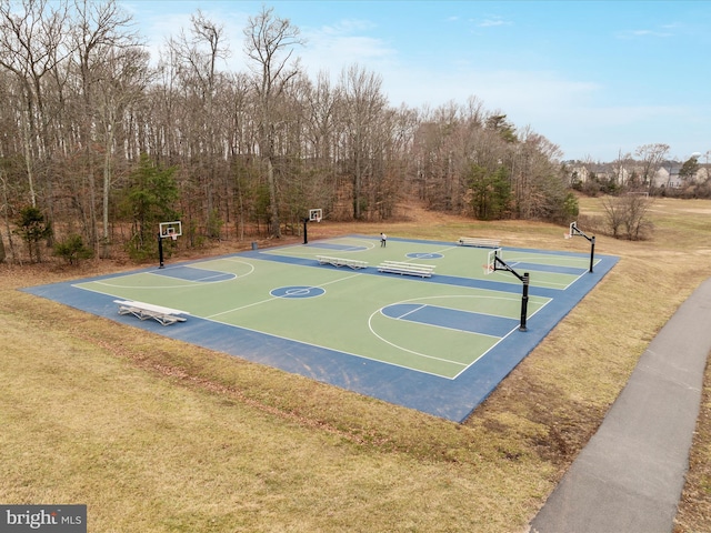 view of basketball court with a yard