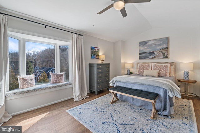 bedroom featuring vaulted ceiling, ceiling fan, wood finished floors, and baseboards