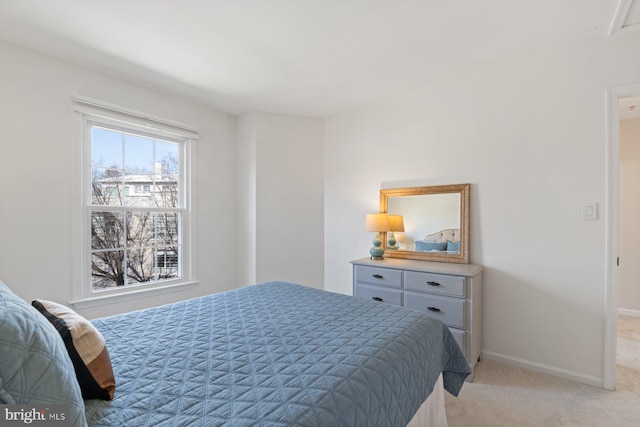 bedroom featuring light carpet and baseboards