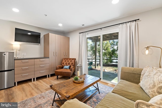 living area featuring light wood-type flooring and recessed lighting