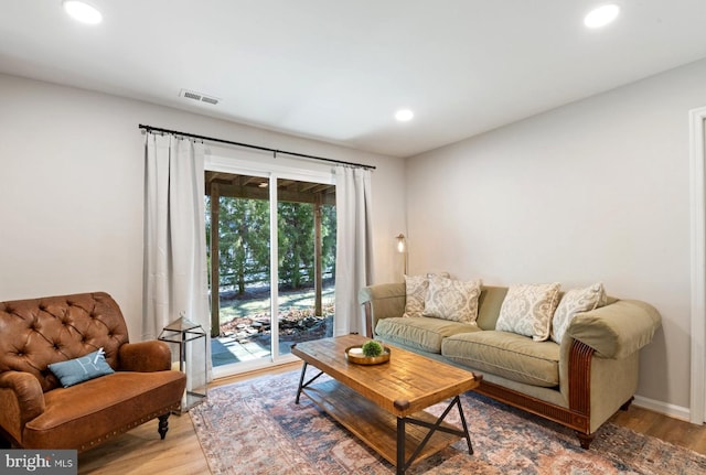 living area featuring baseboards, wood finished floors, visible vents, and recessed lighting