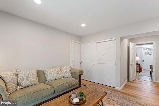 living room with light wood finished floors, baseboards, and recessed lighting