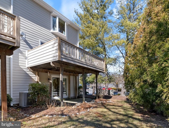 rear view of property featuring cooling unit, a patio area, and a wooden deck