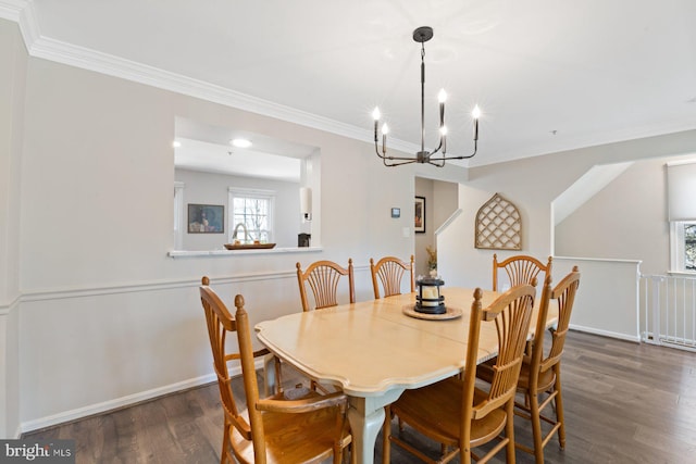 dining room featuring a chandelier, ornamental molding, and wood finished floors