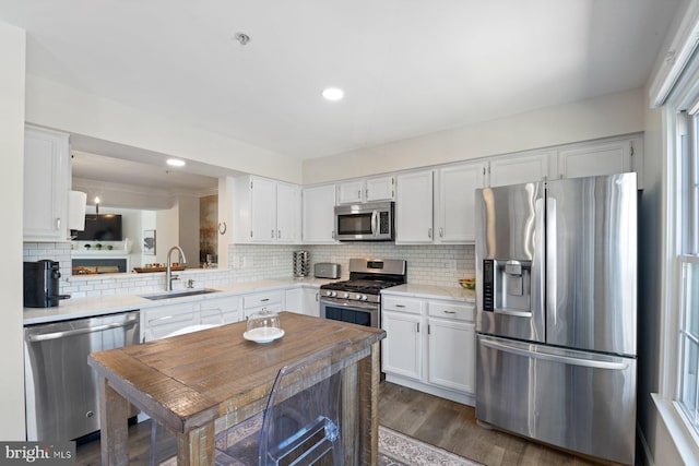 kitchen featuring appliances with stainless steel finishes, white cabinets, light countertops, and a sink