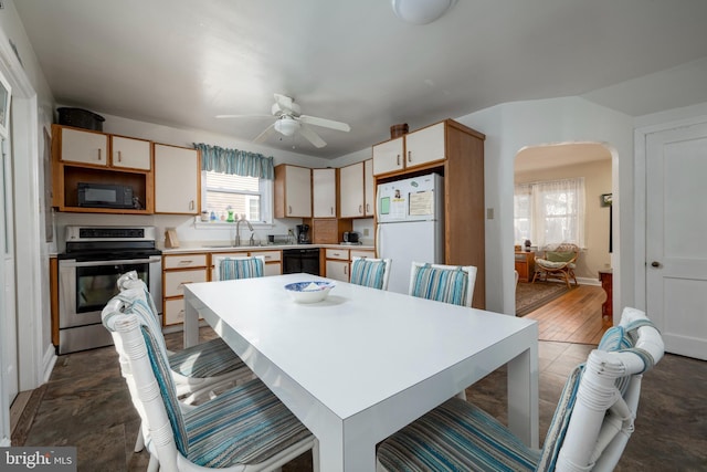 dining space featuring ceiling fan and sink