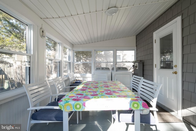 sunroom featuring lofted ceiling, washer and dryer, and a wealth of natural light