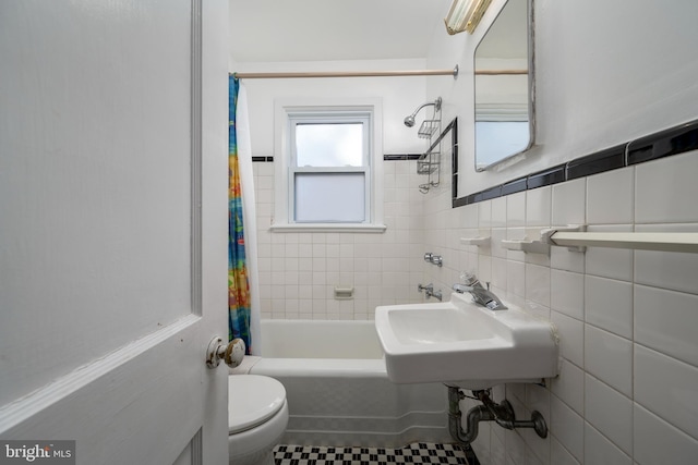 full bathroom with toilet, sink, tile walls, and shower / bath combo