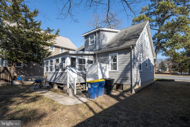 rear view of property with a yard and a sunroom