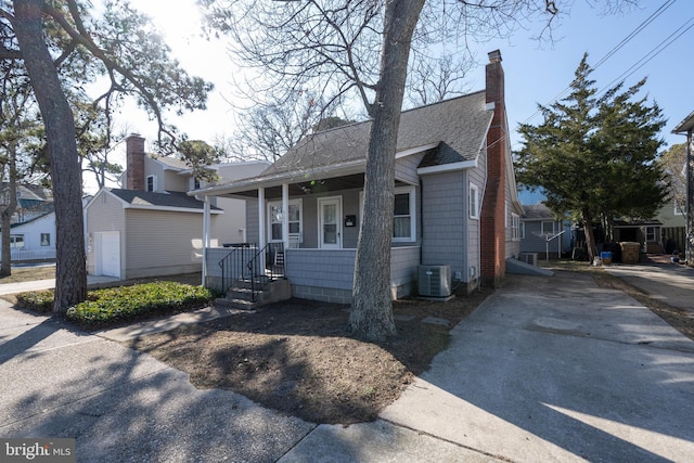 bungalow-style house featuring a porch and central AC