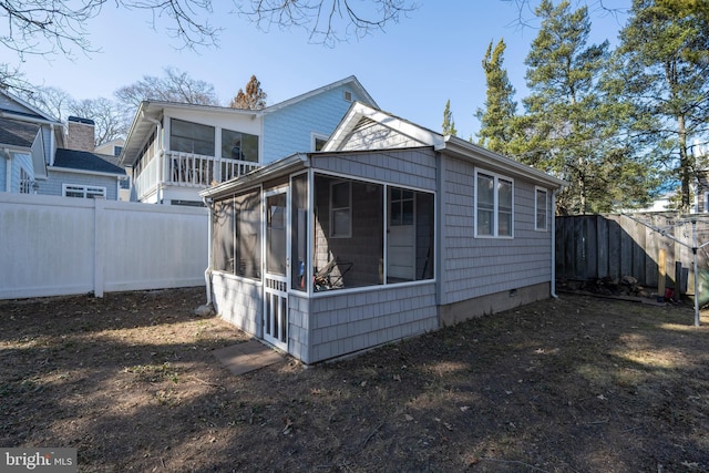 rear view of house featuring a sunroom