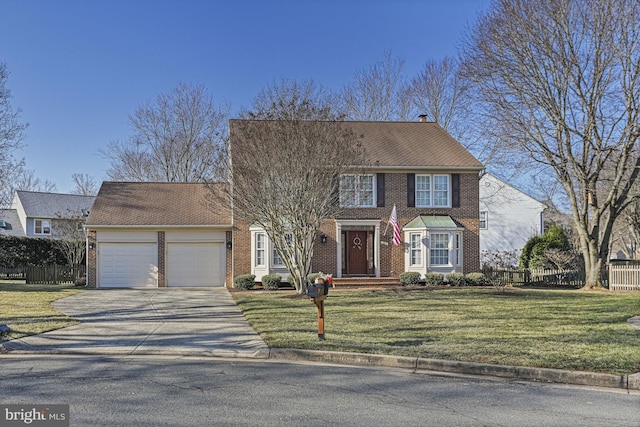 colonial-style house featuring an attached garage, driveway, fence, and a front yard