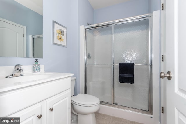 bathroom featuring vanity, an enclosed shower, and toilet