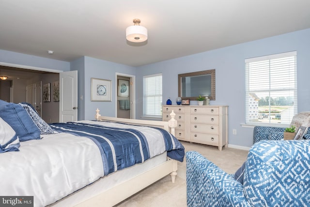 bedroom featuring multiple windows and light carpet