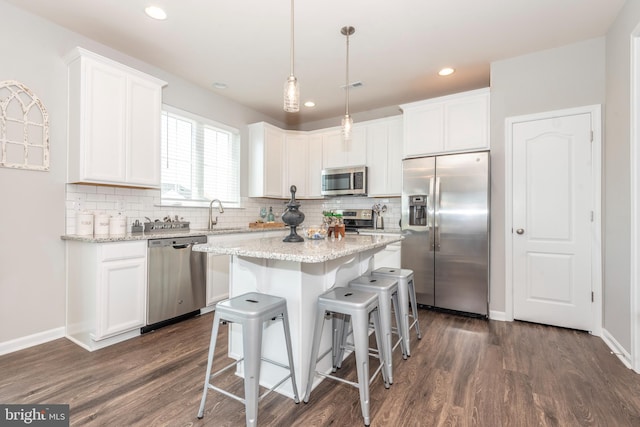 kitchen featuring white cabinetry, pendant lighting, stainless steel appliances, and a kitchen island