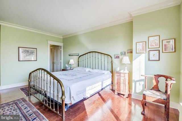 bedroom with hardwood / wood-style floors and ornamental molding