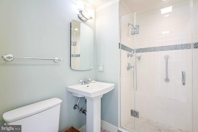 bathroom featuring a shower with shower door, ornamental molding, and toilet