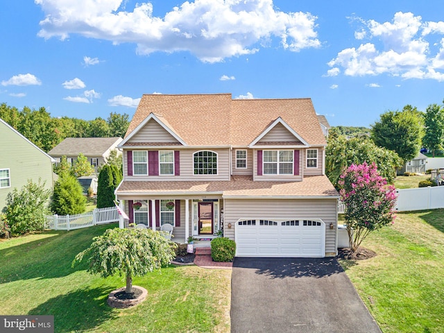 view of front of house featuring a garage, a front yard, and covered porch