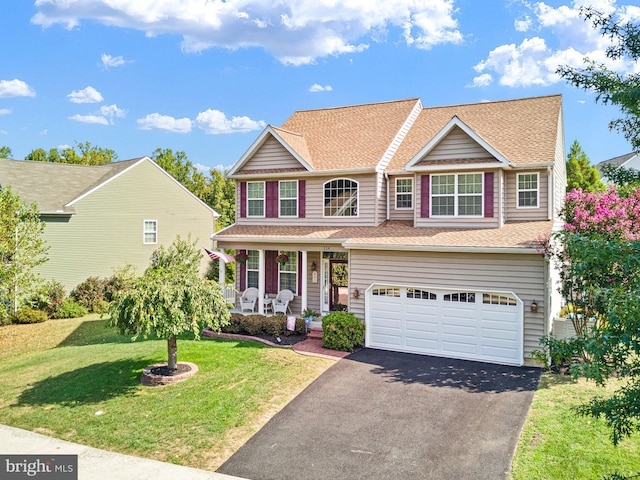 view of front of house with a garage, covered porch, and a front yard