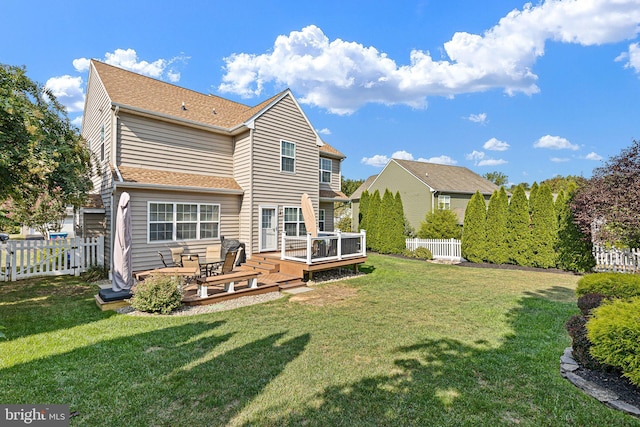 back of house featuring a wooden deck and a lawn