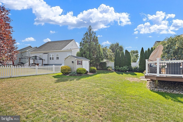 view of yard with a wooden deck and a storage shed