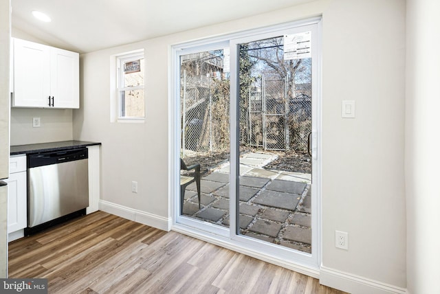 interior space with dishwasher, white cabinets, and light wood-type flooring