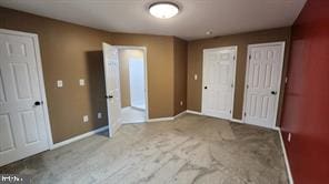 unfurnished bedroom featuring carpet and two closets