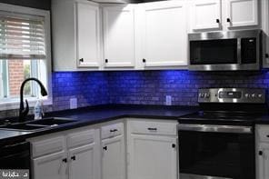 kitchen with white cabinetry, sink, decorative backsplash, and appliances with stainless steel finishes