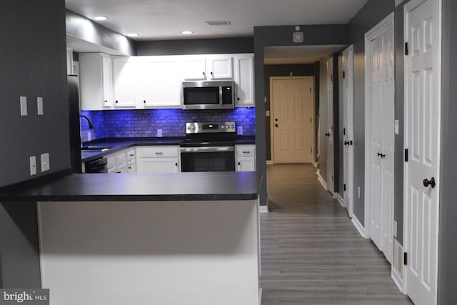 kitchen featuring sink, kitchen peninsula, white cabinets, and appliances with stainless steel finishes