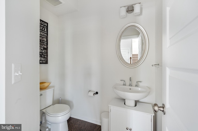 bathroom featuring hardwood / wood-style flooring, toilet, and vanity