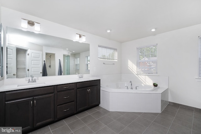 bathroom featuring plus walk in shower, vanity, and tile patterned floors