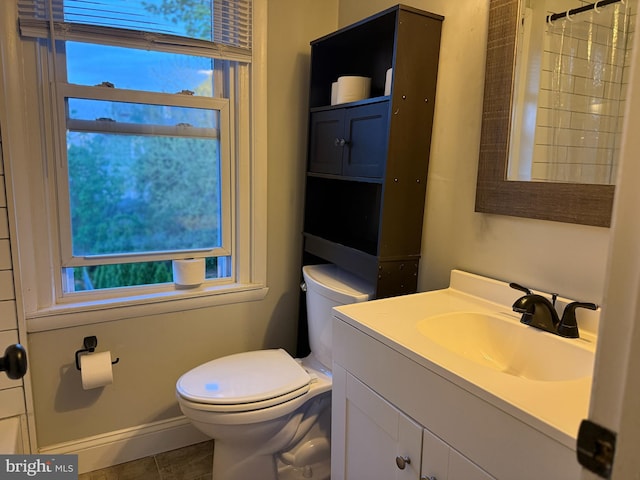 full bathroom with baseboards, a shower with shower curtain, toilet, and vanity