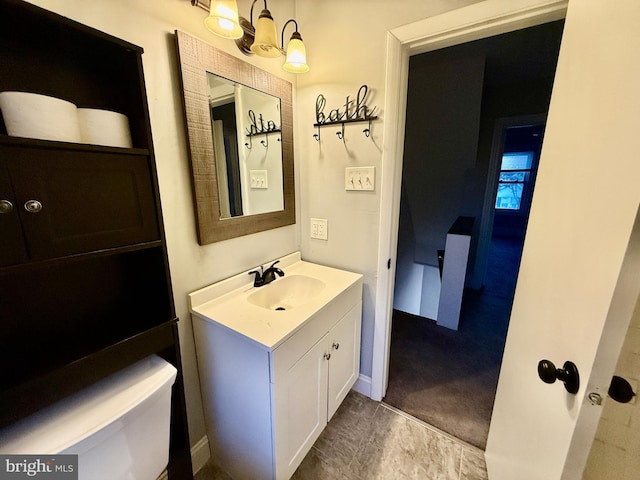 bathroom with vanity, a notable chandelier, and baseboards