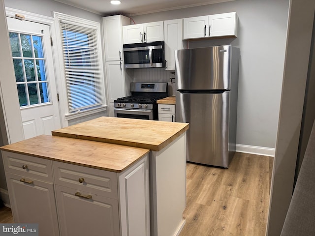 kitchen featuring recessed lighting, light wood-style floors, white cabinets, appliances with stainless steel finishes, and butcher block counters
