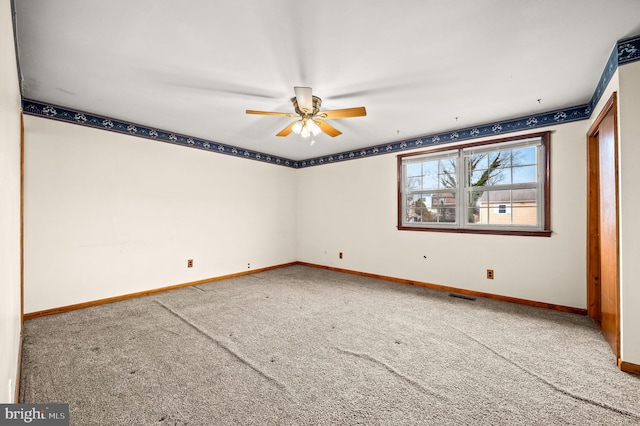 carpeted spare room featuring ceiling fan