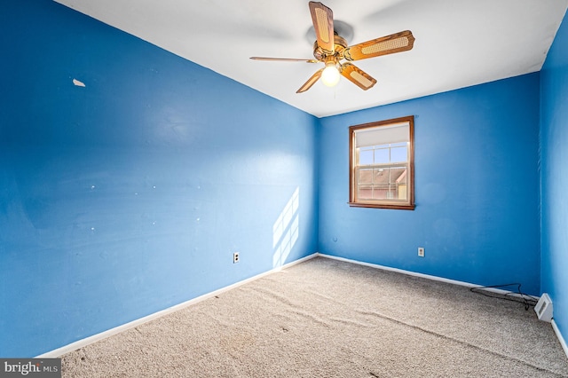 carpeted spare room with ceiling fan