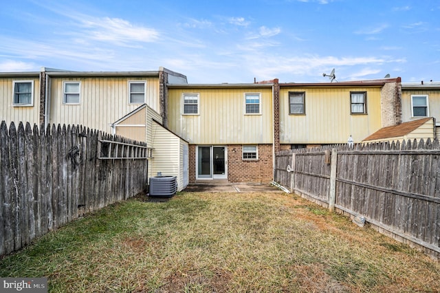 rear view of property featuring a patio, cooling unit, and a lawn