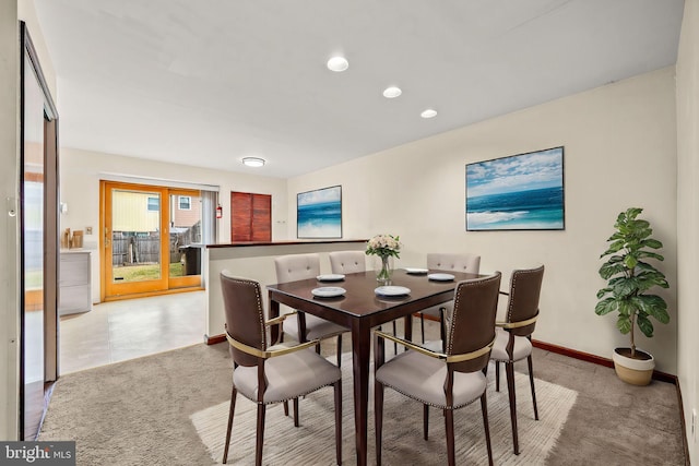 dining area featuring light carpet