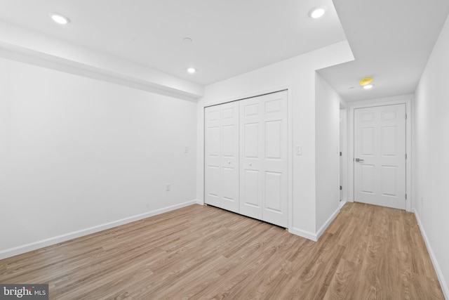 unfurnished bedroom with light hardwood / wood-style floors and a closet