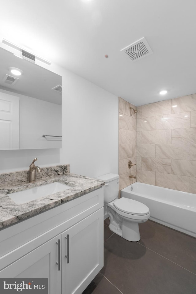 full bathroom with tiled shower / bath combo, vanity, tile patterned flooring, and toilet