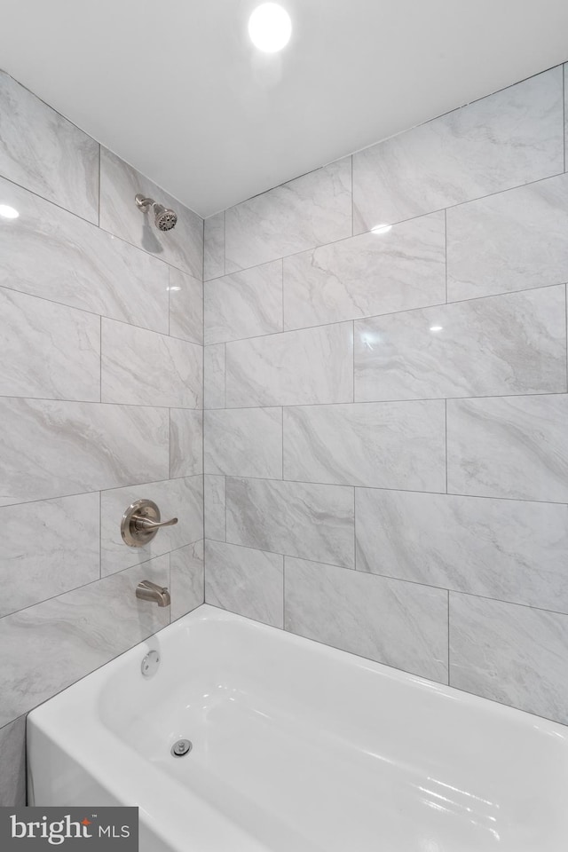 bathroom featuring tiled shower / bath