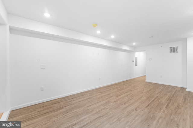 unfurnished room with electric panel and light wood-type flooring