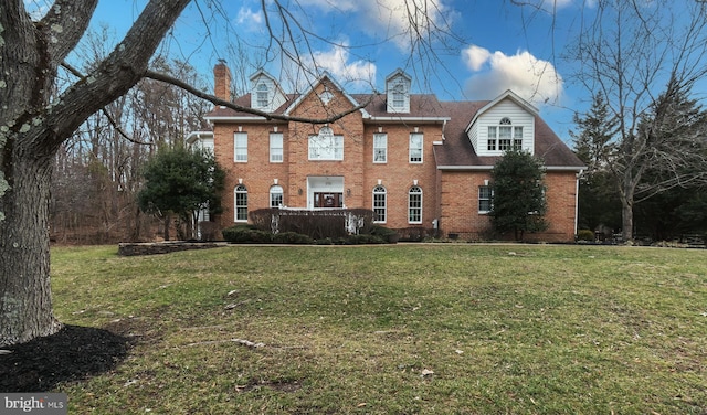 colonial home featuring brick siding and a front lawn