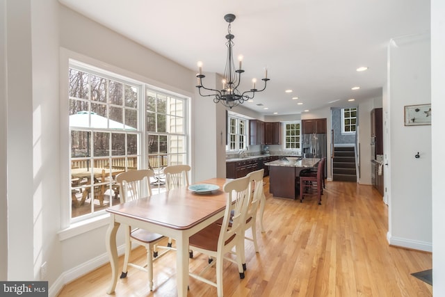 dining room featuring light wood finished floors, a notable chandelier, recessed lighting, and baseboards