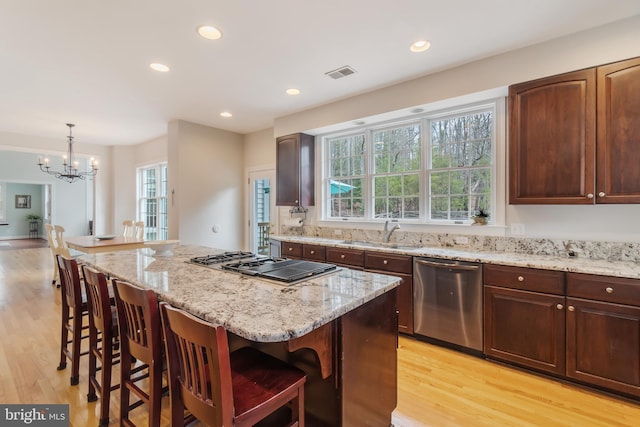 kitchen featuring a sink, visible vents, appliances with stainless steel finishes, and a breakfast bar area