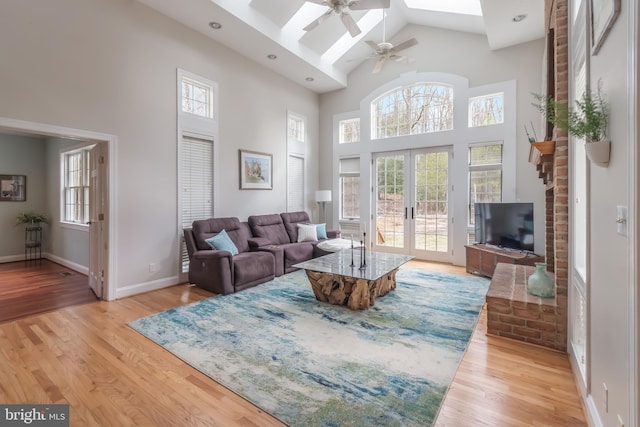 living room featuring light wood-type flooring, french doors, and a healthy amount of sunlight