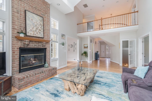 living room featuring visible vents, a fireplace, and wood finished floors