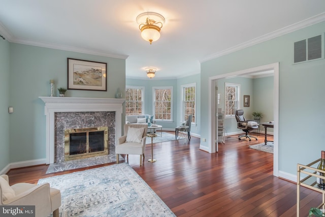 living room featuring visible vents, dark wood-style flooring, crown molding, and a premium fireplace