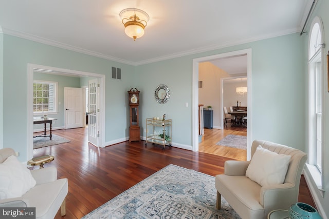 interior space featuring visible vents, ornamental molding, and wood finished floors